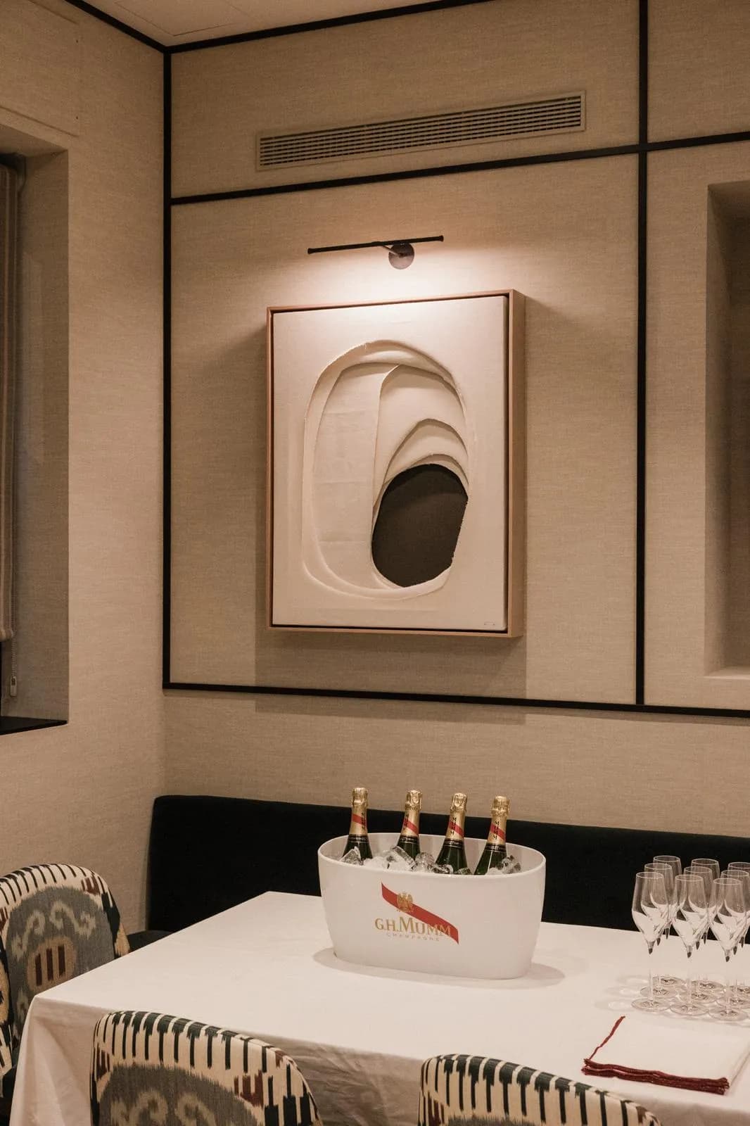 Champán Mumm junto a cuadro de arte y copas